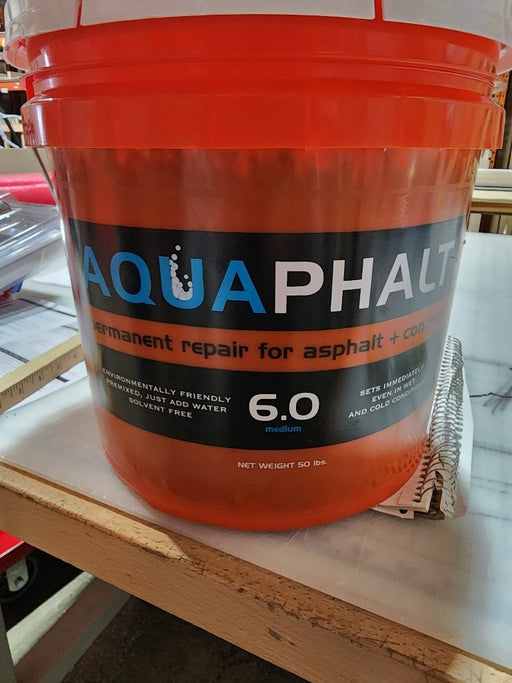 Orange bucket of AquaPhalt 6.0 asphalt and concrete permanent repair